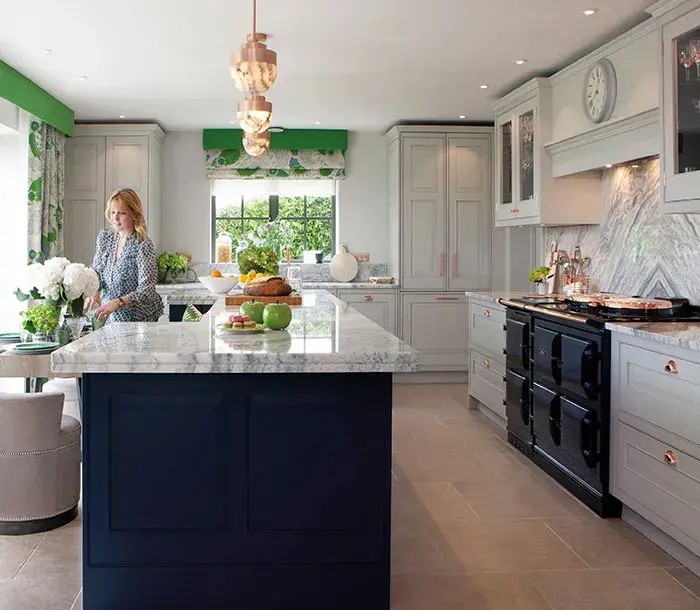 Karen Howes in kitchen with Taylor Howes Blue and copper AGA cooker
